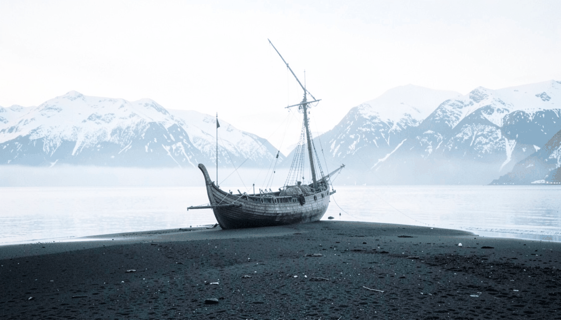 A misty Nordic shoreline at twilight, a lone longship beached on dark sand with snow-dusted mountains rising beyond