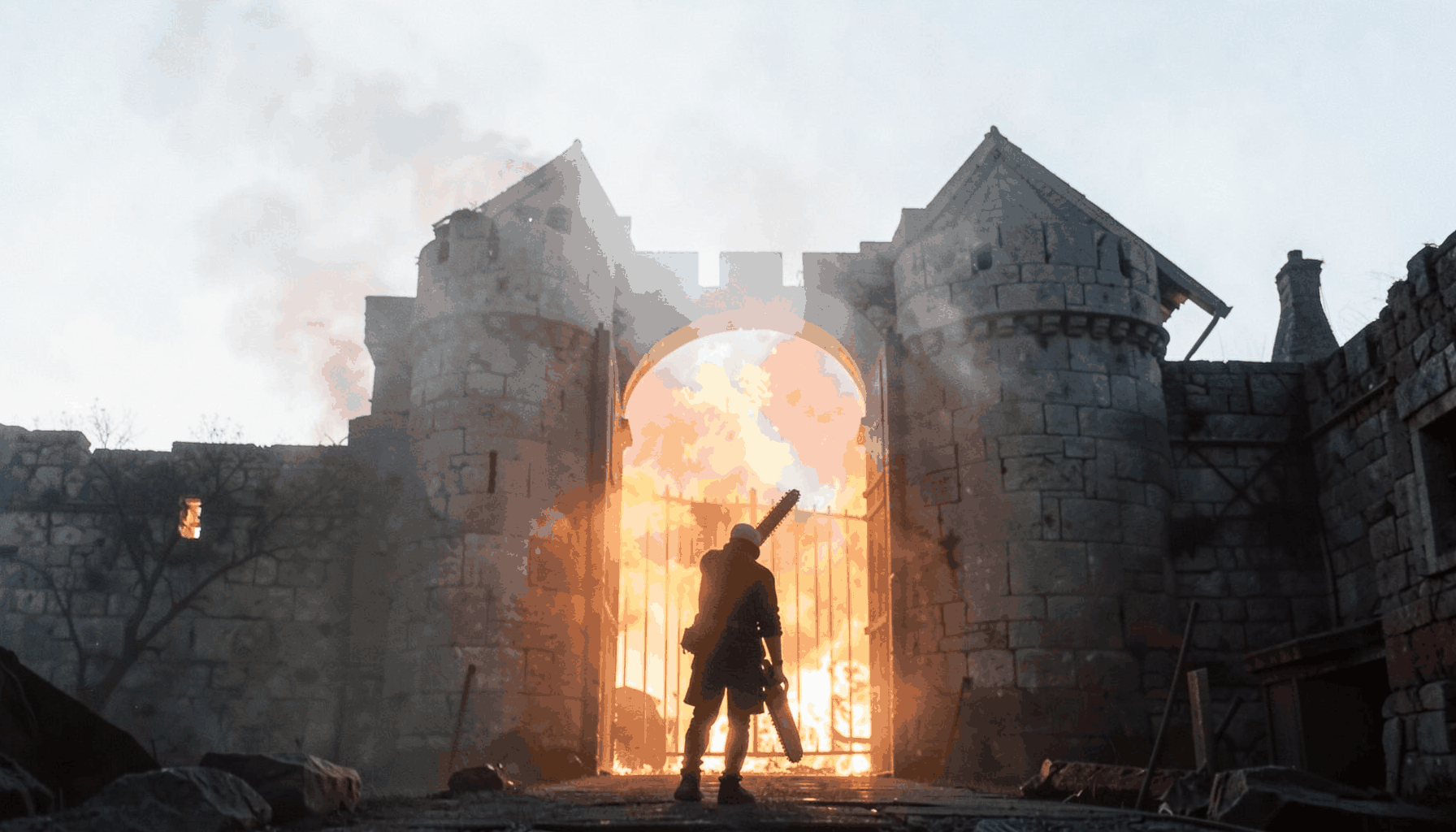 A medieval fortress gate at night, a single figure with a chainsaw arm silhouetted against an orange inferno, smoke billowing into a starless sky